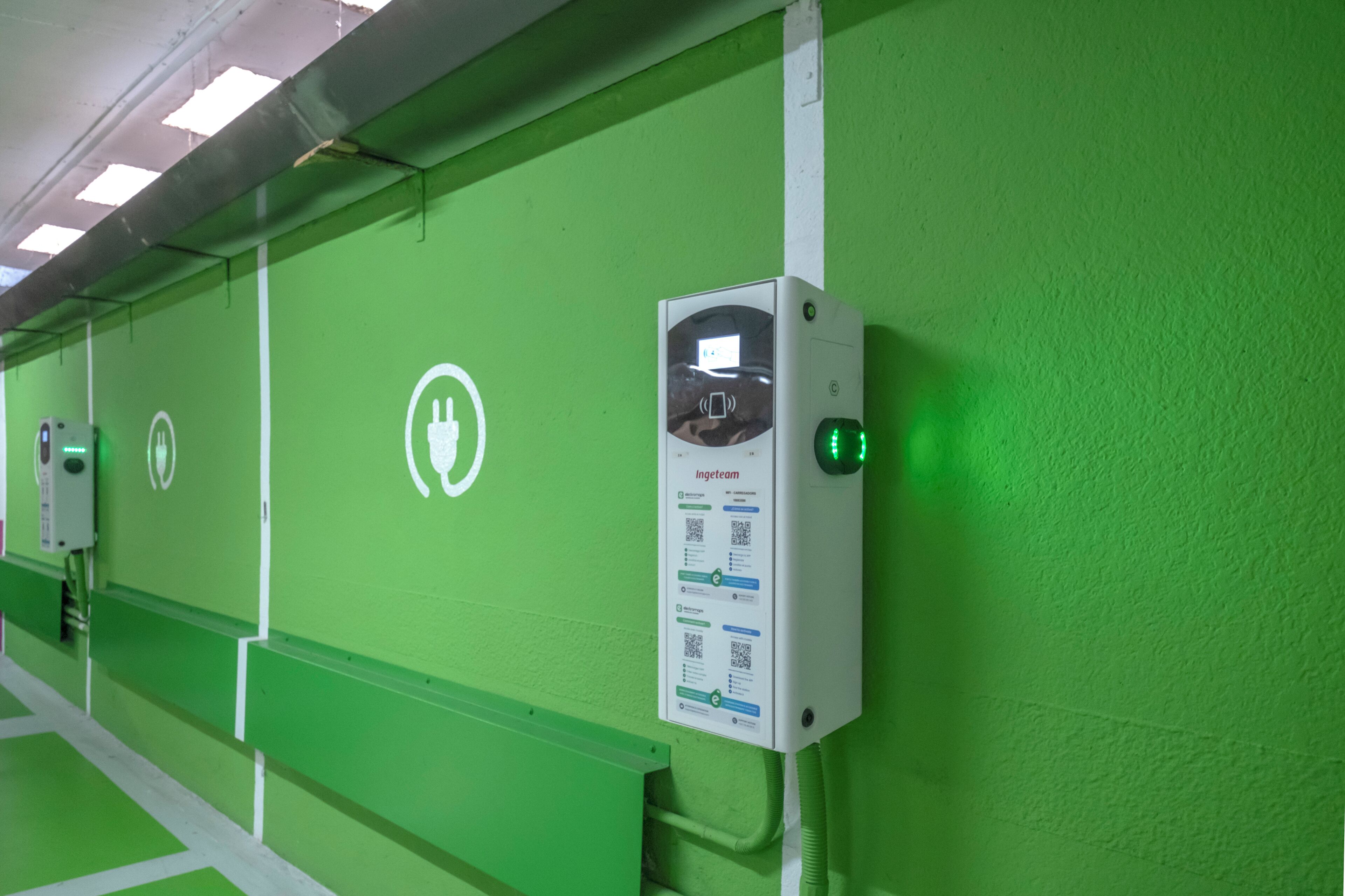 A green wall with a charging station and a QR code for Ingeteam.