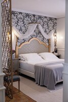 Een netjes opgemaakte slaapkamer met een bed, nachtkastjes en een decoratief hoofdeinde.
