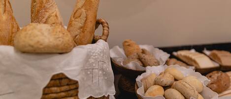 Forskellige slags brød udstillet i kurve, blandt andet baguette og boller.