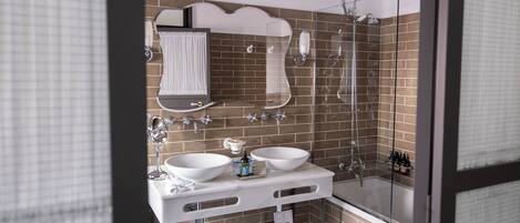 Un baño moderno con dos lavamanos, ducha y zona de ducha con mampara de vidrio.