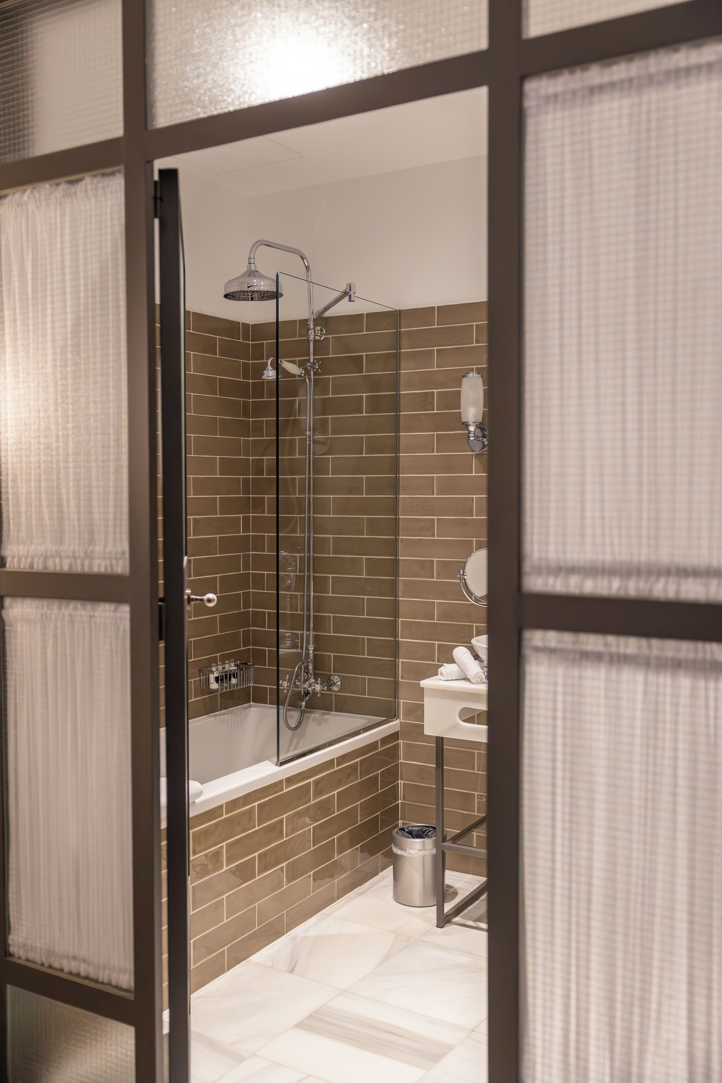 Ein modernes Badezimmer mit einer begehbaren Glasdusche, einer Badewanne und einem WC.