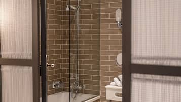 Ein modernes Badezimmer mit einer begehbaren Glasdusche, einer Badewanne und einem WC.