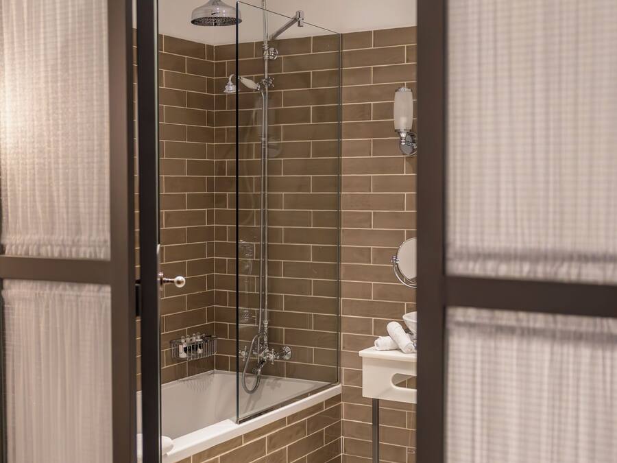 Ein modernes Badezimmer mit einer begehbaren Glasdusche, einer Badewanne und einem WC.