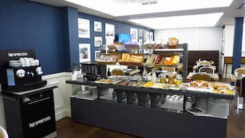 Un bufé de desayuno con diferentes opciones de comida y una máquina de café Nespresso.