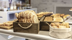 Una vitrina de panadería con distintos tipos de pan y pasteles.