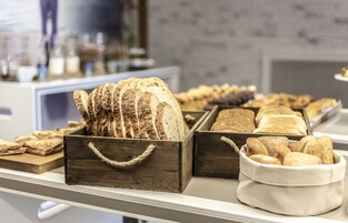 Una vitrina de panadería con distintos tipos de pan y pasteles.