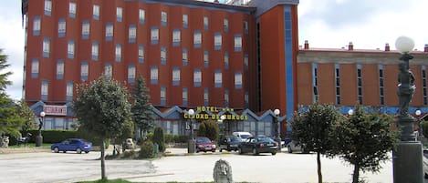 Een hotel met een rode gevel, meerdere ramen en een bord waarop