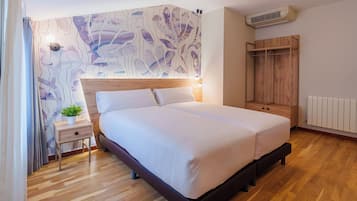 Un dormitorio moderno con cabecera de madera, cama grande, mesita de noche con una planta, armario y radiador.