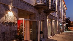 A building with a stone facade, multiple balconies, and a Christmas tree outside. - Hotel Jerónimos 8 (Lisbon)