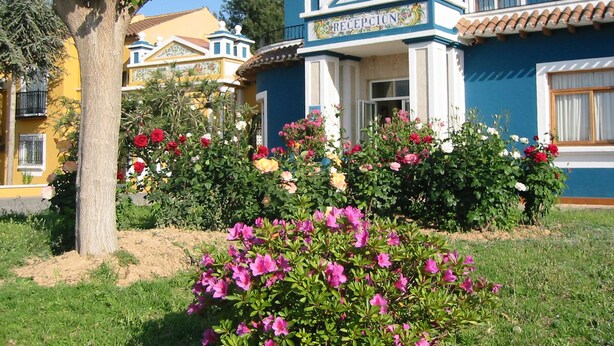 Un bâtiment doté d’un espace d’accueil, entouré d’un jardin où poussent différentes espèces de fleurs.