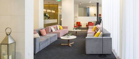 A modern lobby with sofas, a coffee table, and a decorative wall.
