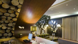 A reception desk with a computer, a glass chair, a potted plant, and a lamp. - Hotel Estrela de Fatima (Ourem)