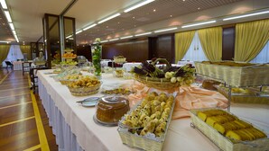 A buffet table with various food items and a mirror reflecting the room.