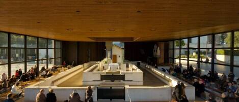 A modern auditorium with tiered seating and a central stage.