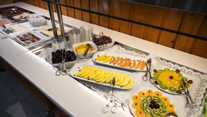 Un bufé con una variedad de alimentos, entre ellos frutas, verduras y postres.