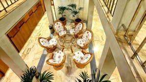 A multi-level atrium with a central seating area featuring wicker furniture and potted plants. - Hotel Flor Parks (Barcelona)