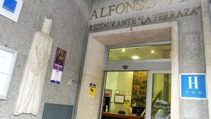 Exterior de l'Hotel Alfonso VIII, Restaurante 'La Terrazza', amb una estàtua, un cartell i un senyal de handicap d'accés blau.
