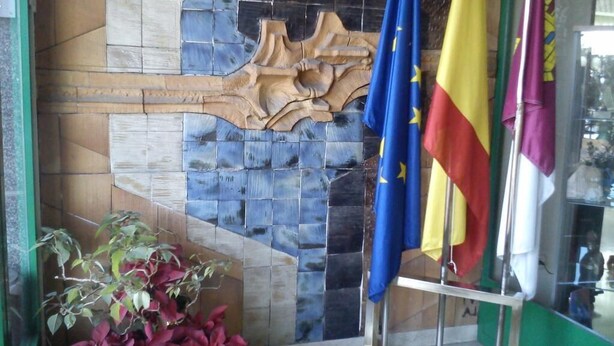 A room with a tiled wall, a wooden sculpture, and flags. - Miralcampo (AZUQUECA DE HENARES)