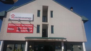 Un edificio con un cartel que indica Hotel Miralcampo y un restaurante llamado Mahou De Castilla.
