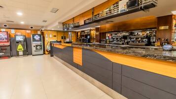 A modern bar area with a counter, bar stools, and a coffee machine.
