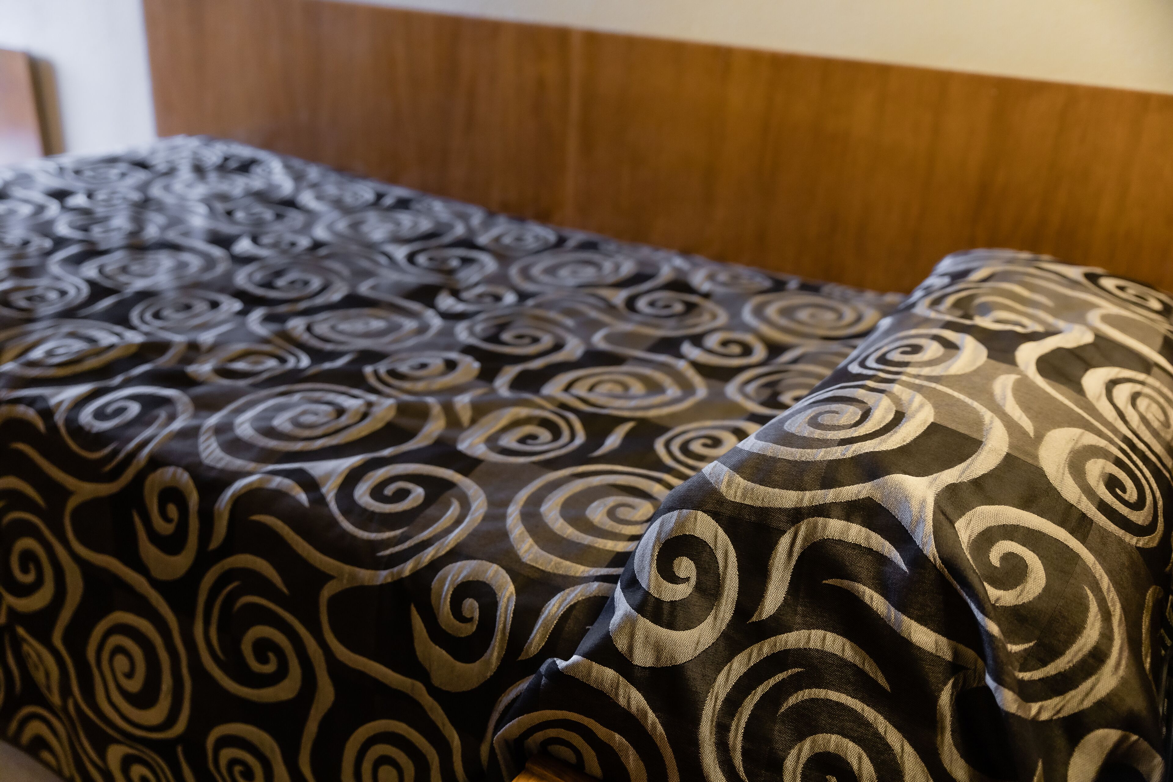 A bed with a patterned cover.