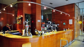 Zona de bar con mostrador de madera pulida, un cantinero y varios objetos de bar.