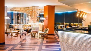 A modern lobby with a patterned floor, wooden furniture, and a seating area with a decorative wall. -  Hotel Civis Jaime I (Castelló de la Plana)