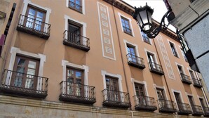 A multi-story building with balconies, a visible storefront with a sign, and a street lamp. - Hotel Sercotel Las Torres Salamanca (Salamanca)