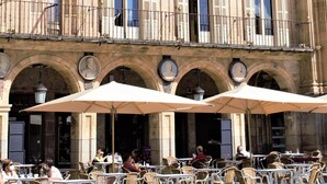 A historic building with multiple balconies and arches, featuring outdoor seating with umbrellas. - Hotel Sercotel Las Torres Salamanca (Salamanca)