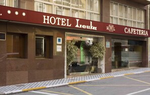 Un edificio con un letrero que dice "HOTEL Leuka" y "CAFETERÍA".