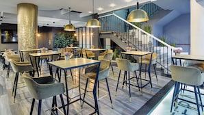 Un restaurante moderno con techos altos, una escalera y una variedad de arreglos de asientos.
