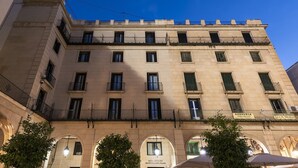 A multi-story building with a symmetrical facade, featuring evenly spaced windows and balconies. - Eurostars Mediterranea Plaza (Alicante)