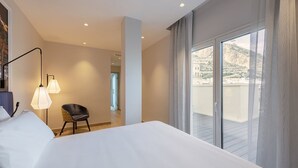 A hotel room with a large bed, a chair, a desk, and a balcony with a view. - Eurostars Mediterranea Plaza (Alicante)