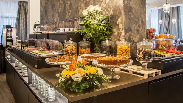 A buffet with various food items and a floral centerpiece. - Best Western Plus CHC Florence (Florence)