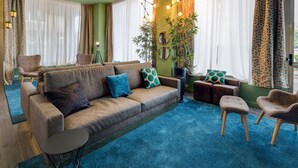 A cozy living room with a sofa, chairs, a small table, and a potted plant. - Best Western Plus CHC Florence (Florence)
