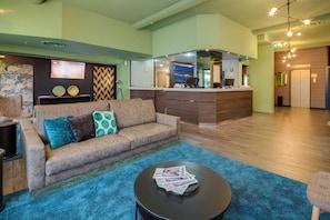 A modern hotel lobby with a sofa, a coffee table, and a reception desk. - Best Western Plus CHC Florence (Florence)