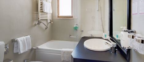 Un baño moderno con bañera, lavabo, inodoro y ducha.