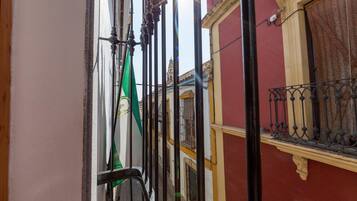Uma rua estreita com edifícios em ambos os lados, com varandas adornadas por grades de ferro forjado.
