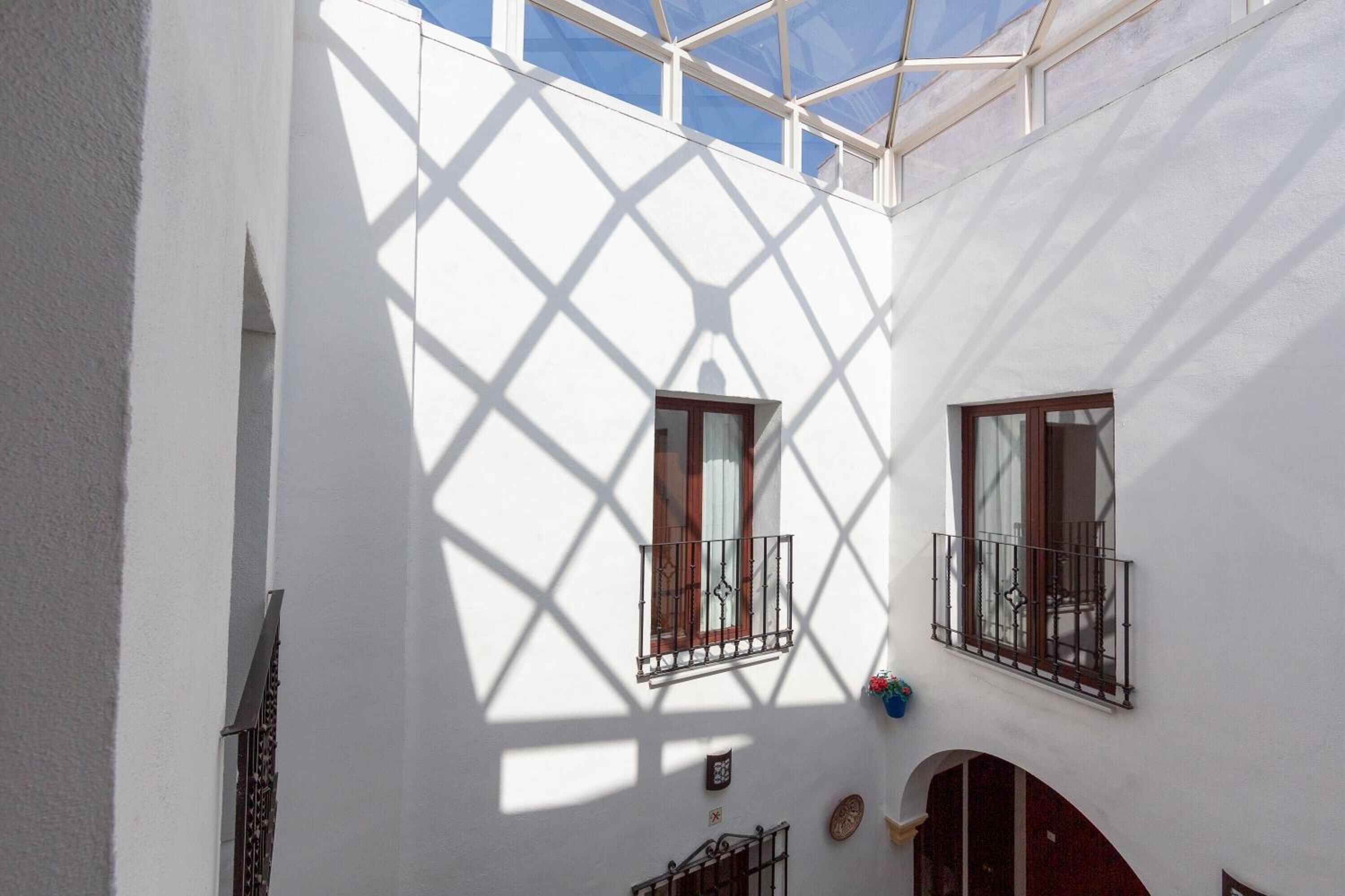 Un edificio blanco con dos ventanas, una con balcón.