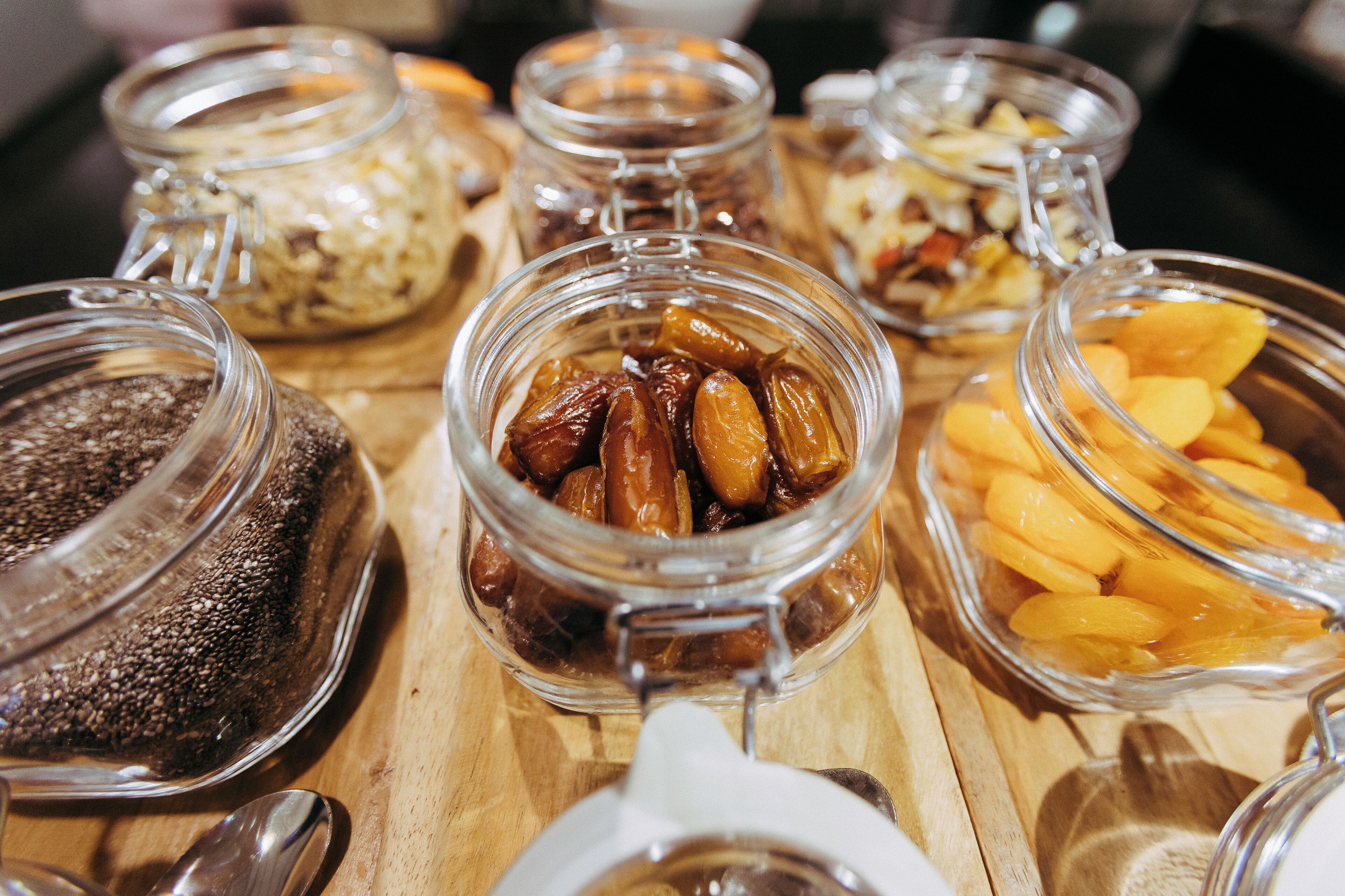 Variedad de alimentos en recipientes de vidrio sobre una mesa de madera.