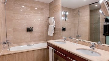 Une salle de bain moderne avec deux lavabos, une baignoire et un grand miroir.