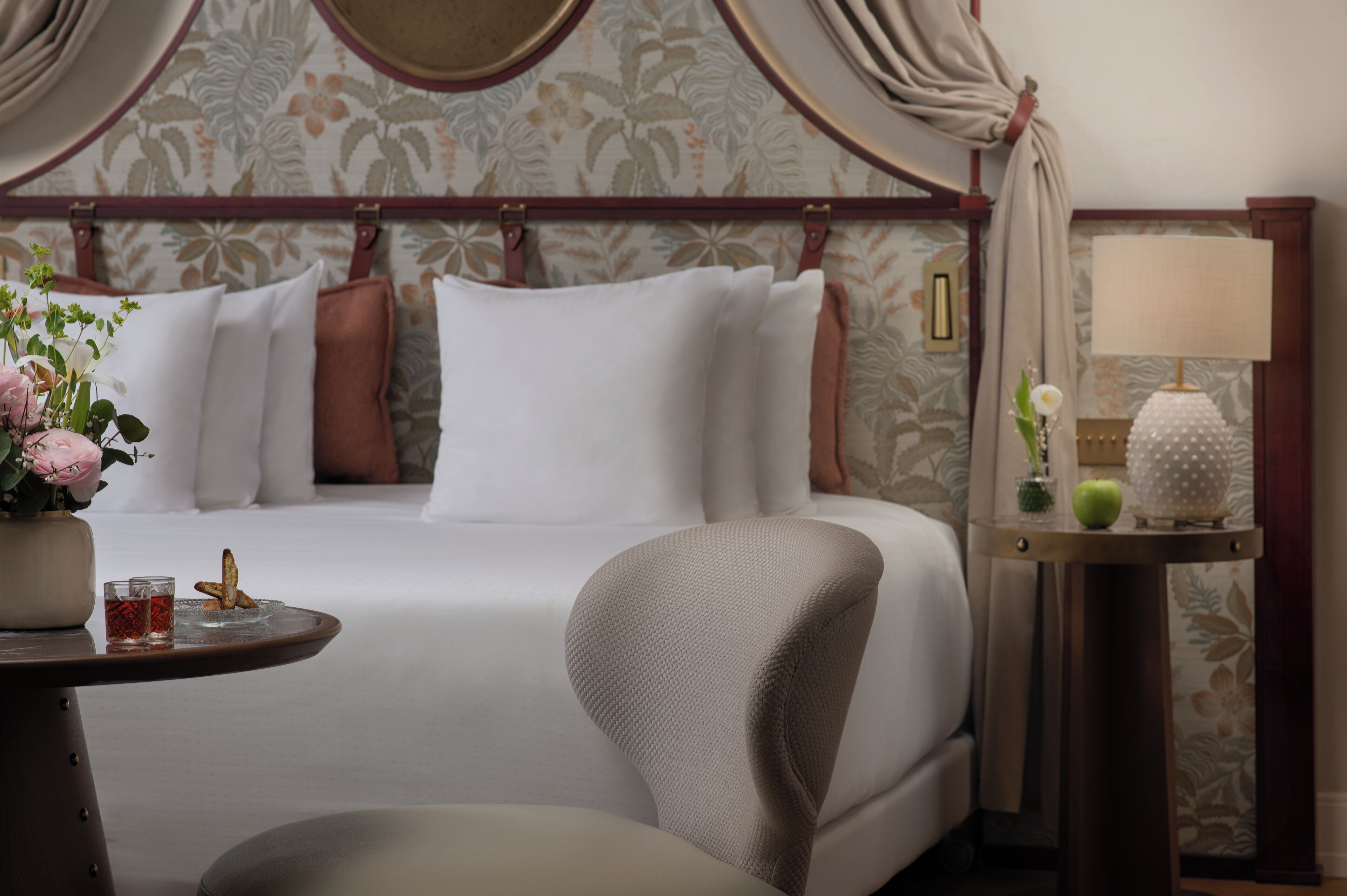 Une chambre d’hôtel avec un grand lit, une table de chevet avec une lampe et une chaise.