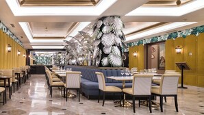 Un restaurant doté d’un long comptoir, de plusieurs tables et de chaises.