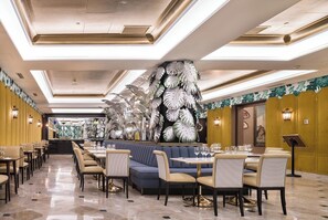 A restaurant with a long counter, multiple dining tables, and chairs. - Hotel Principe Pio (Madrid)