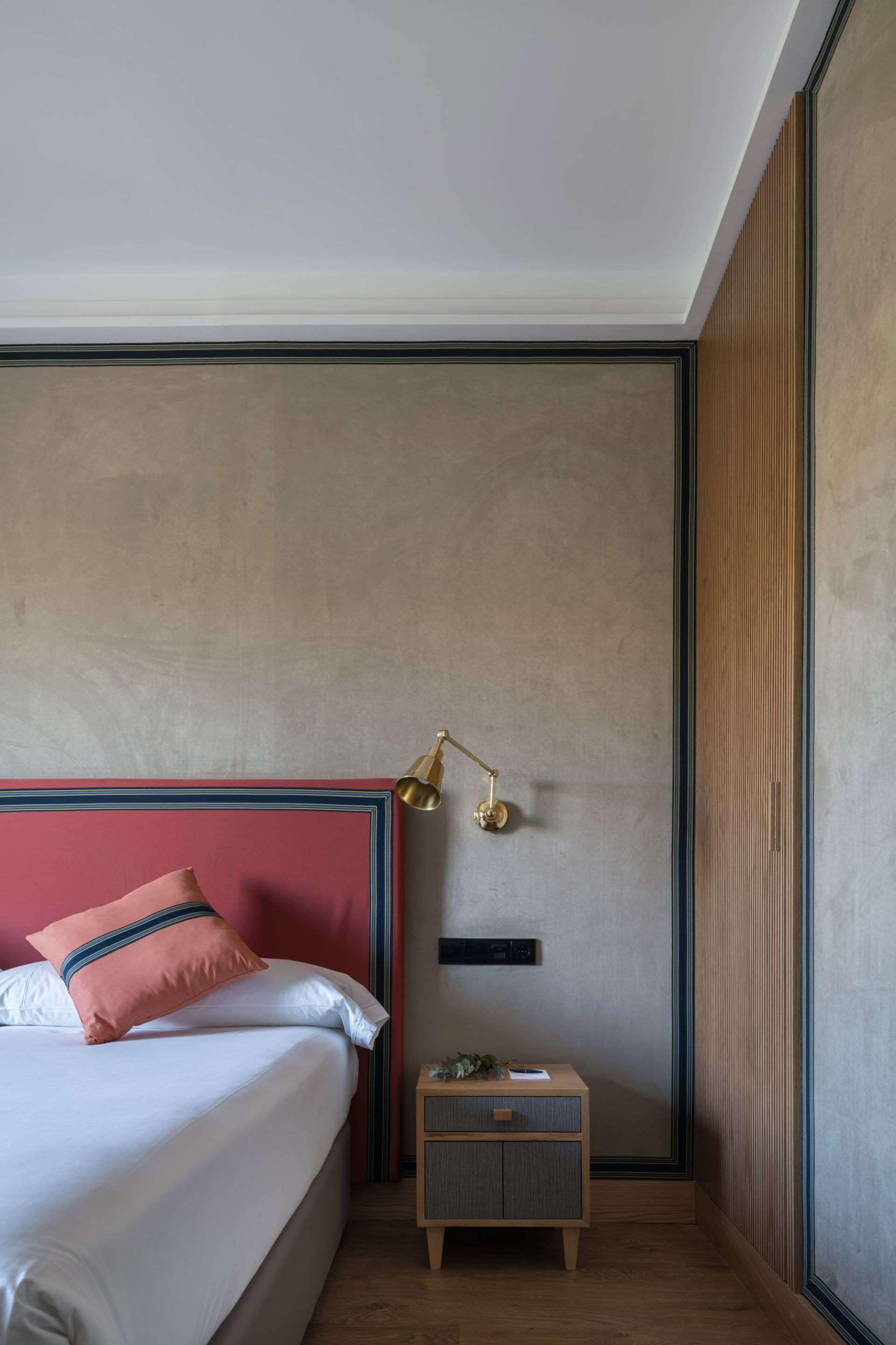A bedroom with a bed, bedside table, and a nightstand.