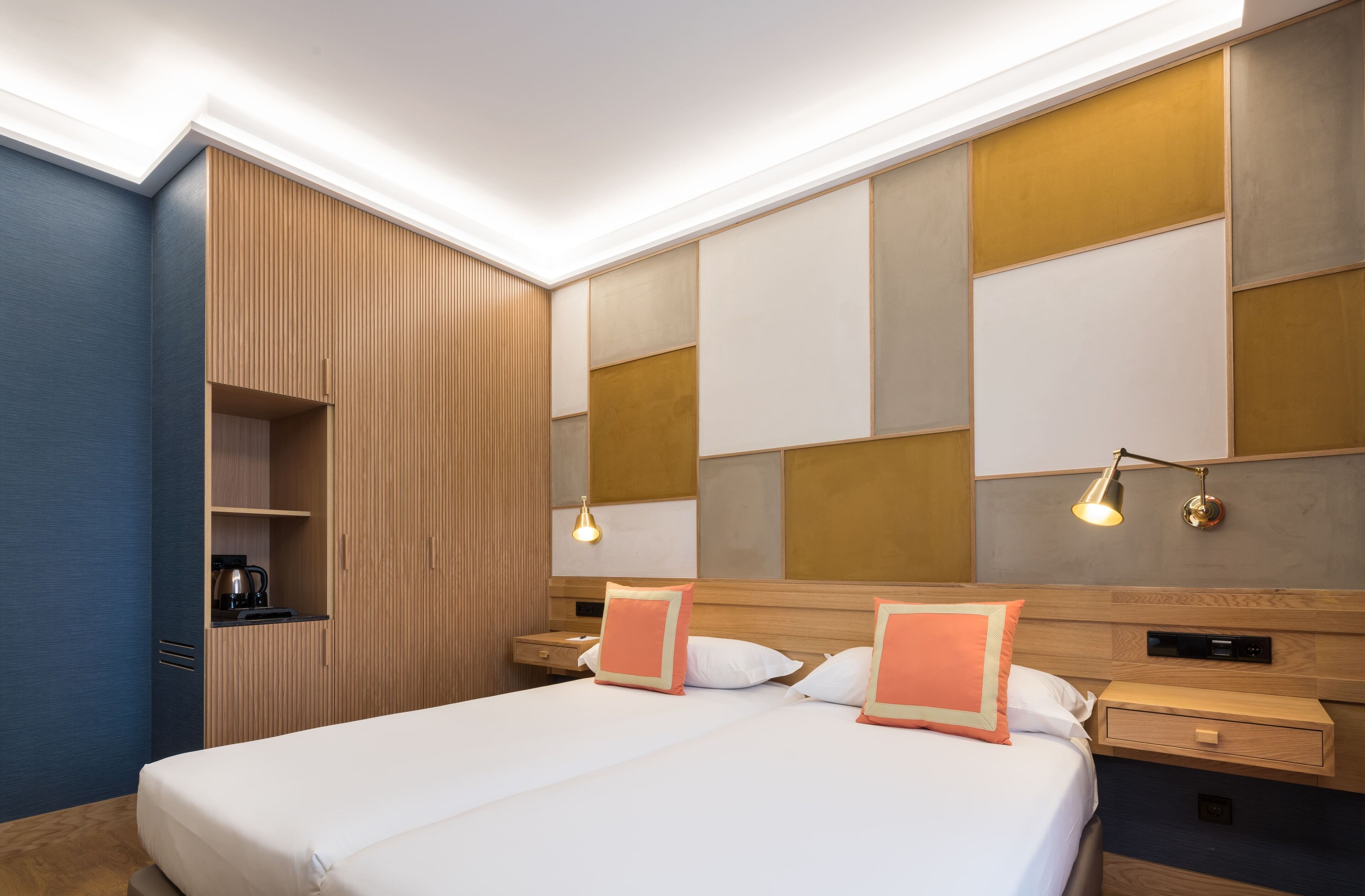 Een hotelkamer met een groot bed, twee nachtkastjes, een inbouwkast en een tv aan de muur.