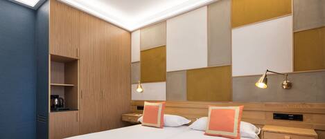 A hotel room with a large bed, two bedside tables, a built-in wardrobe, and a wall-mounted TV.