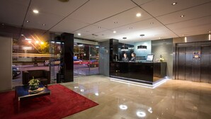 A modern lobby with a reception desk, a seating area, and an elevator. - Hotel Zentral Ramiro I Oviedo (Oviedo)
