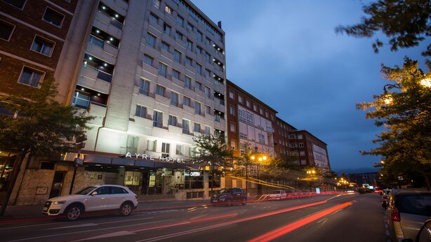 A multi-story hotel with a modern facade, a visible restaurant, and a well-lit street at dusk. - Hotel Zentral Ramiro I Oviedo (Oviedo)