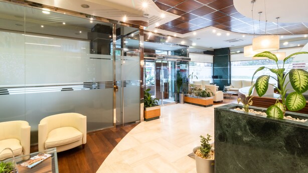 A modern lobby with glass doors, a reception desk, and seating areas. - Hotel Regio Cadiz (Cádiz)